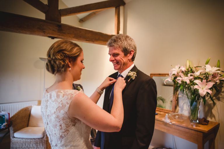 bride fixing her father's buttonhole